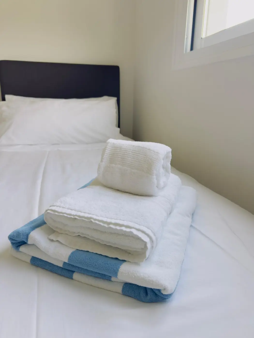 Fresh towels arranged on a made bed
