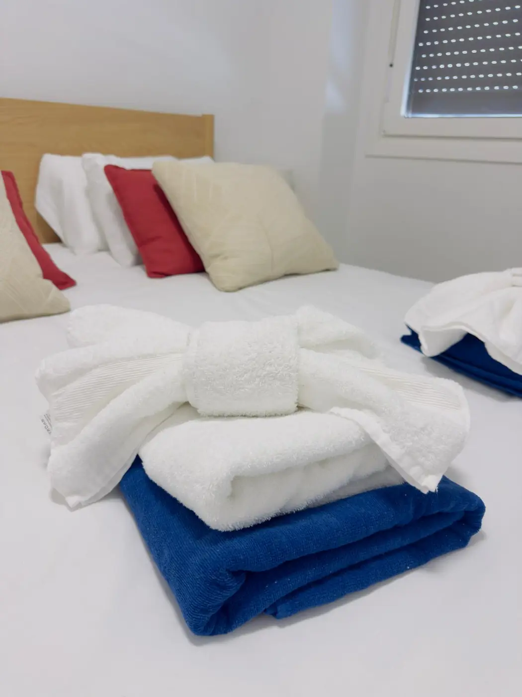 Freshly prepared bedroom with folded towels on the bed
