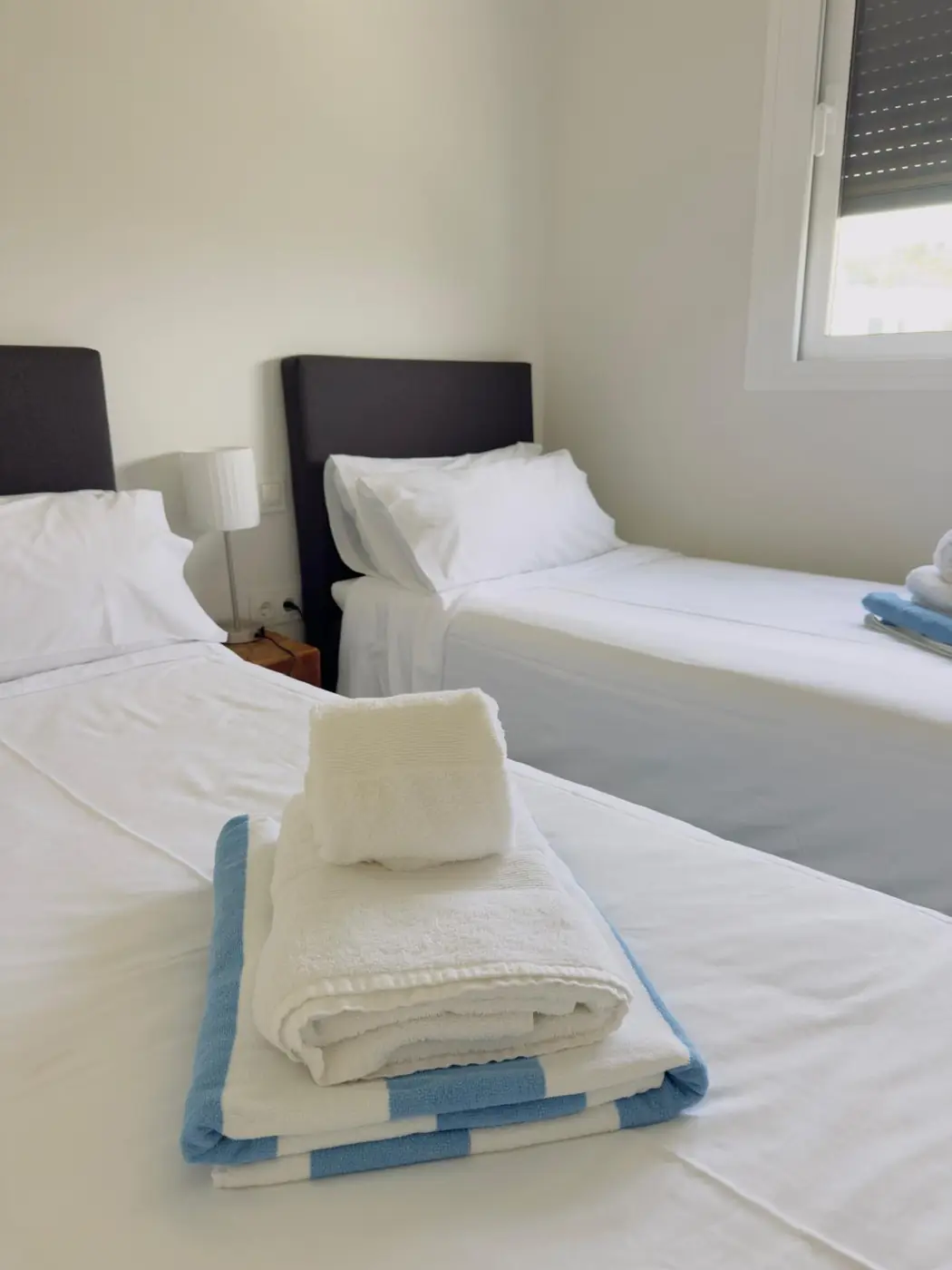 Freshly prepared twin bedroom with folded towels